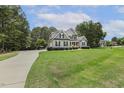 Traditional two-story home with lush green lawn and long driveway leading to the property at 205 Sherman Pines Dr, Fuquay Varina, NC 27526