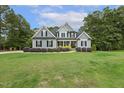 Traditional two-story home with a manicured lawn, complemented by mature trees and a serene setting at 205 Sherman Pines Dr, Fuquay Varina, NC 27526