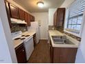 The kitchen features tile backsplash, a window with natural light, and white appliances at 2146 Charles St # 12, Durham, NC 27707