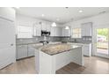 Well-lit kitchen with white cabinets, granite countertops, stainless appliances, and an eat-in island at 222 Trailing Oak Trl, Clayton, NC 27527