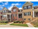 Brick townhome with black shutters and a well-manicured lawn at 231 Grindstone Dr, Apex, NC 27502