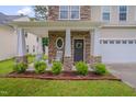 Cozy front porch featuring stone columns, rocking chairs, and manicured landscaping for added curb appeal at 3019 Britmass Dr, Raleigh, NC 27616