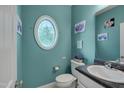 Stylish powder room with a unique oval window, adding character and natural light to the space at 3019 Britmass Dr, Raleigh, NC 27616