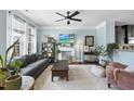 Bright living room featuring a fireplace, ceiling fan, and a comfortable seating area at 309 Old Mill Village Dr, Apex, NC 27502