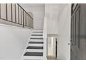 Bright, minimalist entryway featuring black-and-white stairs and a view into an adjacent room at 309 Penn Oak Cir, Raleigh, NC 27615