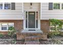 A welcoming front entrance featuring a brick porch, neutral door, and manicured landscaping at 309 Penn Oak Cir, Raleigh, NC 27615
