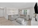 Bright living room with a gray sectional sofa, plush ottoman, and neutral-toned rug, perfect for relaxation at 309 Penn Oak Cir, Raleigh, NC 27615
