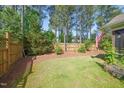 Fenced-in backyard with mature trees and landscaping offers privacy and a serene outdoor space at 320 Trout Valley Rd, Wake Forest, NC 27587
