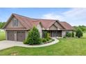 Traditional home featuring a brick and vinyl exterior, a two-car garage, and beautifully landscaped yard at 3465 Covington Trl, Mebane, NC 27302
