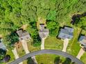 An aerial view showcasing the house in a lush, green, tree-lined neighborhood with well-manicured lawns at 347 Manchester Trl, Clayton, NC 27527
