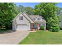 Charming home with manicured lawn, two-car garage, and inviting brick-lined front porch at 347 Manchester Trl, Clayton, NC 27527