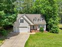 Charming home featuring a manicured lawn, two-car garage, and inviting brick-lined front porch at 347 Manchester Trl, Clayton, NC 27527