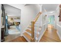 Inviting entryway featuring hardwood floors, staircase with wooden handrail and white risers at 4 Barkridge Ct, Durham, NC 27713