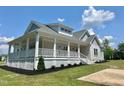 Beautiful home featuring a spacious, covered wraparound porch with white columns and railing at 4016 Berman Edge Rd, Holly Springs, NC 27540
