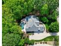An aerial view of the home, pool, and surrounding mature trees providing privacy at 404 Settlecroft Ln, Holly Springs, NC 27540