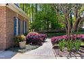 Stone walkway next to brick exterior with blue shutters and mature landscaping at 404 Settlecroft Ln, Holly Springs, NC 27540