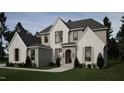 Beautifully designed two-story home boasting stone accents, a covered entryway, and well-manicured landscaping at 404 Shinleaf Pond Trl, Raleigh, NC 27614