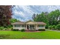 Beautiful home with manicured lawn, front porch, and a serene, tree-lined backdrop at 41 Maple Cir, Pittsboro, NC 27312