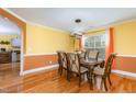 Bright dining room with hardwood floors, a contemporary chandelier, and a pass-through to the kitchen at 412 Collington Dr, Mebane, NC 27302