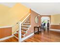 Inviting foyer showcasing wood floors, a staircase with decorative iron railing, and a glimpse into adjacent rooms at 412 Collington Dr, Mebane, NC 27302