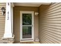 Close-up of the front door entrance, highlighting the secure screen door and siding at 412 Collington Dr, Mebane, NC 27302