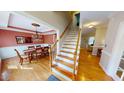 Inviting foyer with wood floors, a staircase, and views into the dining room and living spaces at 5305 Balmy Dawn Ct, Raleigh, NC 27613