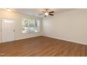 Open living area with wood-look flooring, ceiling fan, and large window for natural light at 5742 Corbon Crest Ln, Raleigh, NC 27612