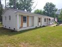 Side view of the white brick ranch house featuring wood shutters and well-manicured lawn at 623 Glenwood Dr, Sanford, NC 27330