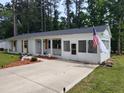 Front exterior of a white brick home with a screened porch and an American flag at 623 Glenwood Dr, Sanford, NC 27330