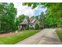 Craftsman style home with stone accents, neutral siding, and lush green lawn, with a long driveway at 677 Juliette Ct, Creedmoor, NC 27522