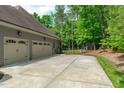 Spacious three car garage with a concrete driveway and a view of the fenced-in backyard at 677 Juliette Ct, Creedmoor, NC 27522