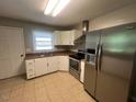 Spacious kitchen with white cabinets and a stainless steel refrigerator at 727 Queens Ave, Dunn, NC 28334