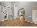 Inviting foyer with hardwood floors, staircase, and neutral paint creating a bright and open entrance at 8517 Evans Mill Pl, Raleigh, NC 27613
