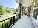 Spacious front porch featuring stone accents and black railings, with a pleasant neighborhood view at 8813 Moss Glen Dr, Raleigh, NC 27617