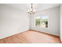 Bright dining room with hardwood floors, a window for natural light, and an elegant chandelier at 900 Borage Dr, Wake Forest, NC 27587