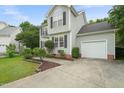 Light green two-story home featuring an attached garage and a well-maintained, neatly edged lawn at 900 Borage Dr, Wake Forest, NC 27587