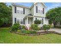 Beautiful landscaping and garden beds accent the front of this well-maintained two-story home at 900 Borage Dr, Wake Forest, NC 27587