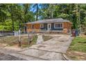 Charming single-story home featuring a brick and siding exterior with a fenced yard and mature trees at 903 Da Vinci St, Durham, NC 27704
