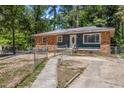 Charming single-story home featuring a brick and siding exterior with a fenced yard and mature trees at 903 Da Vinci St, Durham, NC 27704