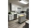 Bright kitchen features white cabinets, stainless steel appliances, and a convenient kitchen island at 940 Pamela Ln, Rocky Mount, NC 27803