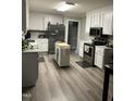 Spacious kitchen with stainless steel appliances, center island, and stylish vinyl flooring at 940 Pamela Ln, Rocky Mount, NC 27803