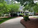 Charming home with mature trees, lush lawn, and inviting covered porch for outdoor enjoyment at 1009 Bearglades Ln, Raleigh, NC 27615