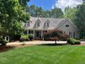 Inviting home exterior features a lush front lawn, mature trees, and a charming covered porch at 1009 Bearglades Ln, Raleigh, NC 27615