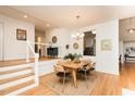 Elegant dining area with hardwood floors and modern light fixture, connecting seamlessly to other living spaces at 103 Harrington Pt, Chapel Hill, NC 27516