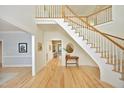 Bright foyer featuring hardwood floors, an elegant staircase, and hallway views with natural light at 107 Silo Dr, Chapel Hill, NC 27514