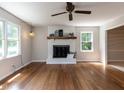 Spacious living room featuring hardwood floors, a fireplace, and natural light from two windows at 113 Honeysuckle Ln, Durham, NC 27703