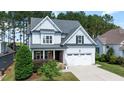 Charming two-story home with light blue siding, stone accents, an attached garage, and a well-manicured lawn at 1132 Heritage Knoll Dr, Wake Forest, NC 27587