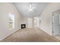 Bright living room with fireplace, neutral carpet, ceiling fan, and a view into other rooms at 11340 Involute Pl # 100, Raleigh, NC 27617