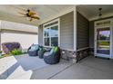 Relaxing front porch featuring comfortable wicker seating, a ceiling fan, and stylish decor at 120 Bramble Ln, Clayton, NC 27527