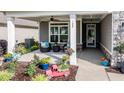 Inviting front porch with seating, potted plants, and decorative accents creating a welcoming entrance at 120 Bramble Ln, Clayton, NC 27527